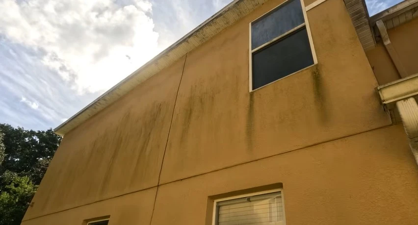 Dirty stucco walls with mold and mildew before pressure washing in West Palm Beach